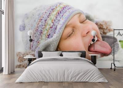 Girl in snow sticking out tongue Wall mural