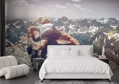 Man Scrambling Over Rocks on Mountain Ledge Wall mural