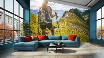 Strong female hiker with backpack pauses on path Wall mural