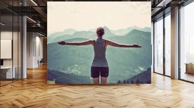 Woman celebrating nature and reaching the summit Wall mural