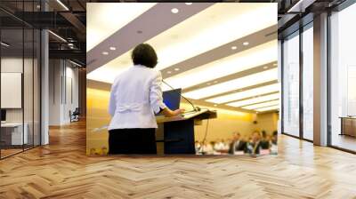 Business woman is making a speech in front of a big audience at a conference hall.. Wall mural