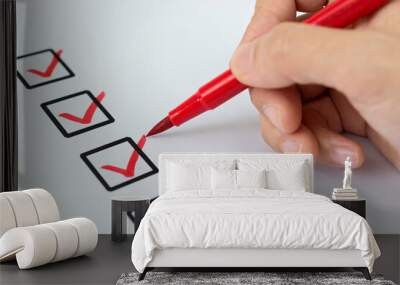 Closeup of hand with red pen marking check box Wall mural