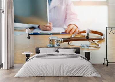 Doctor at work with a stethoscope on desk Wall mural