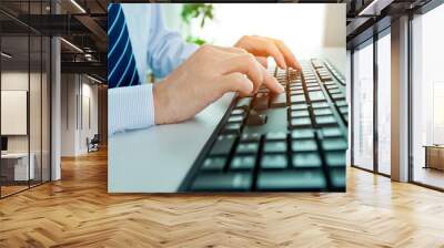 Male office worker typing on the keyboard Wall mural