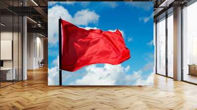 Red flag waving against blue sky Wall mural