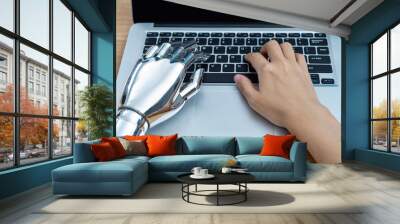 Robot hand and human hand using laptop Wall mural