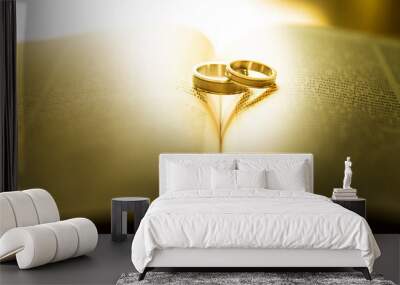 Two wedding rings with heart shadow  on a bible page Wall mural