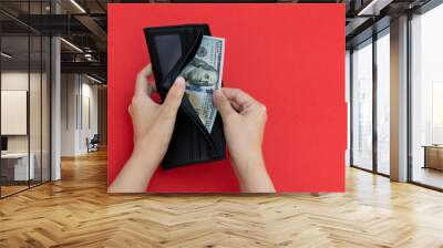 Woman hand holding a leather wallet with dollar Wall mural