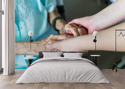 Young woman hand touch and hold an old woman's wrinkled hands Wall mural