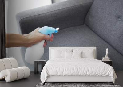 Sprayed air freshener in hand on home interior background Wall mural