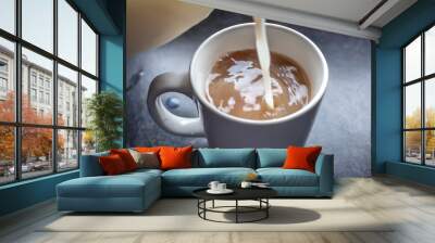 Pouring semi skimmed milk in to a cup of English breakfast tea with intentional motion blur in the cup Wall mural