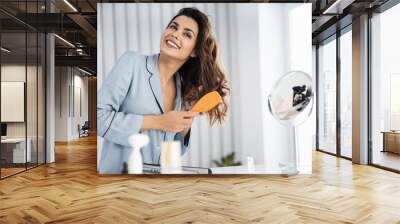 Beautiful young female brushing healthy hair at home Wall mural