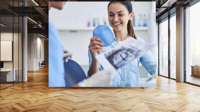 Beautiful young lady checking results of dental treatment Wall mural