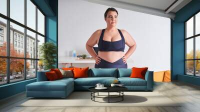 Body positive woman breathing and looking away before doing exercise at home Wall mural