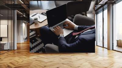 Businessman in hotel hall with laptop and documents on the background Wall mural