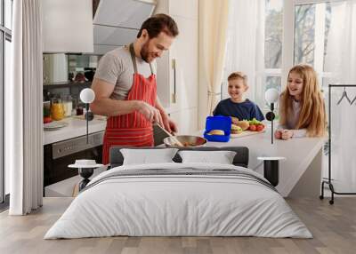 Caring father preparing breakfast for kids Wall mural