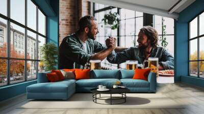 Cheerful friends in arm-wrestling pose looking at each other and smiling Wall mural