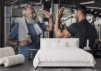 Cheerful males are talking to each other in modern gym Wall mural