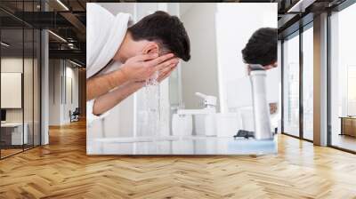 Close up of dark haired man washing his face Wall mural