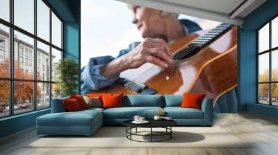 Close up of mature woman performing song while looking aside. Focus on musical instrument Wall mural