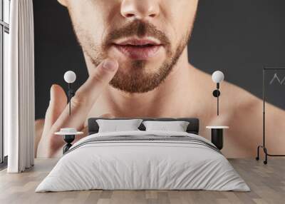 Close up of young bearded man showing index finger up Wall mural