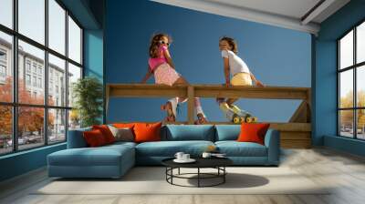 Funny girls turn to the camera while sitting at the wooden bridge Wall mural