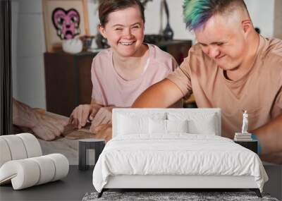 Girl with special needs laughing out loud while looking how her friend rolling out Wall mural