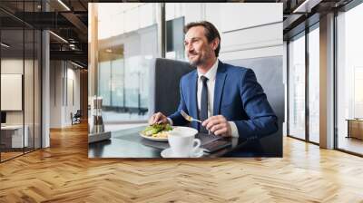 Happy businessman dreaming during dinner Wall mural