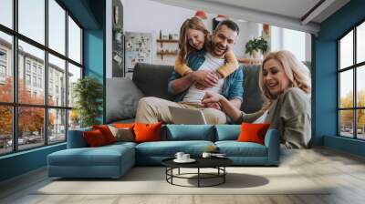 Happy family watching videos on laptop at home Wall mural