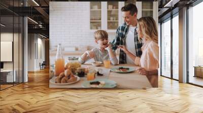 Happy kid opening his mouth and getting piece of banana Wall mural