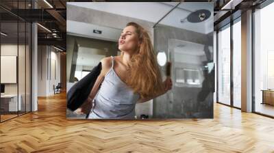 Happy lady pretending to sing using hairdryer Wall mural