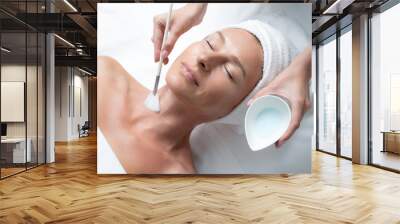 Having great day at spa. Top view close up portrait of smiling middle aged woman with closed eyes receiving skincare procedure Wall mural