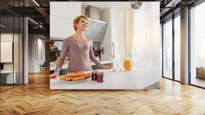 Joyful woman dreaming in cook room Wall mural