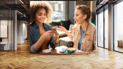 Laughing females telling in confectionary shop Wall mural