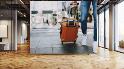 Male is carrying luggage in hall before trip Wall mural