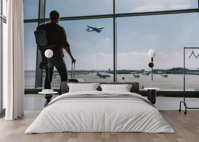 Man is watching plane flying from airport Wall mural