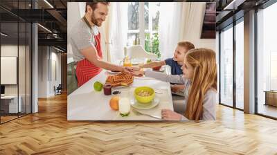 Merry kids having fun with parent during breakfast Wall mural