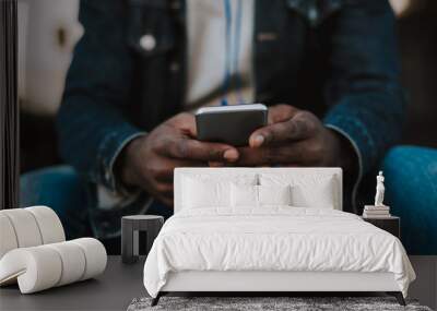 Modern user. Close up of a smartphone being used by a yougn afro american man Wall mural