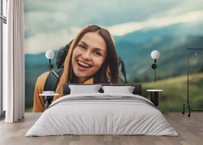 overjoyed smiling young woman expressing positivity while resting in the mountains Wall mural