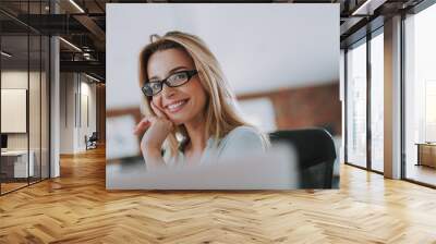 Pretty woman in glasses posing and touching her cheek Wall mural