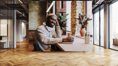 Relaxed student smiling while sitting in coworking center Wall mural