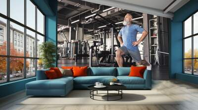 Senior male with beard is enjoying time in sports club Wall mural