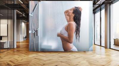 Side view beaming female taking shower while gesticulating hands. She touching head Wall mural