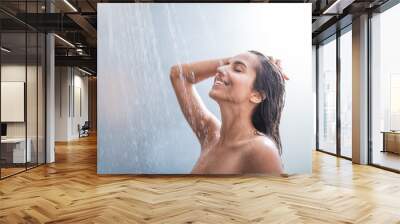 Side view happy woman washes body and hair under stream of hot water Wall mural