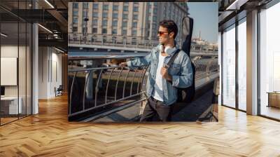 Smiling musician looking on the city view Wall mural