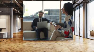 Two guests of a business hotel communicating at lobby by wi-fi Wall mural