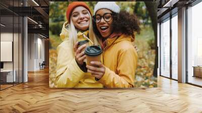 Two young females walking in park together Wall mural