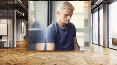 upset old male person taking seat near window, he is holding gadget in hand and looking down with fr Wall mural