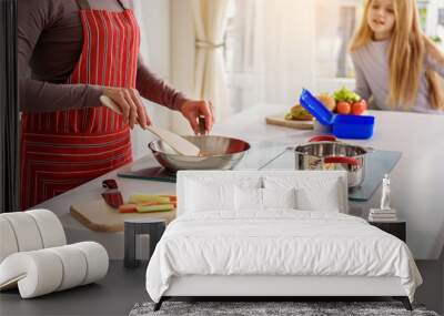 Woman teaching her child to cook Wall mural