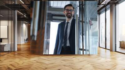 Young businessman coming in the hotel in a good mood Wall mural